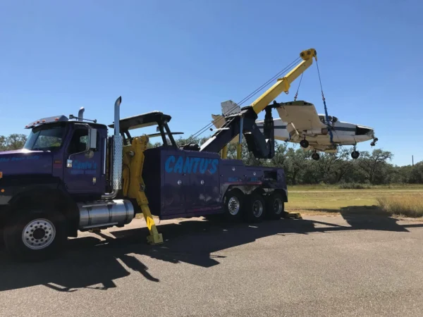 INT-60 integrated wrecker lifting a broken plane with boom extended during recovery operation