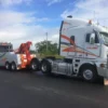 INT-60 integrated wrecker towing a semi truck on the road shoulder during breakdown recovery