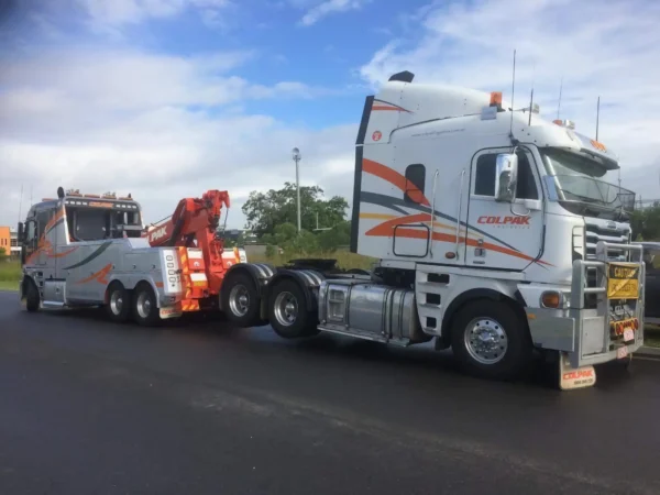INT-60 integrated wrecker towing a semi truck on the road shoulder during breakdown recovery