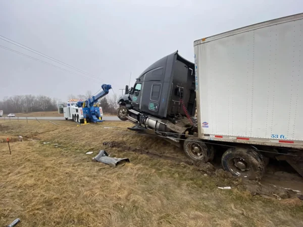 INT-60 heavy duty integrated wrecker recovering a tractor-trailer from roadside terrain