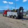 INT-60 integrated wrecker preparing for heavy vehicle towing with stabilizers and rear boom extended