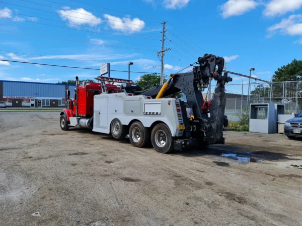 INT-60 integrated wrecker preparing for heavy vehicle towing with stabilizers and rear boom extended