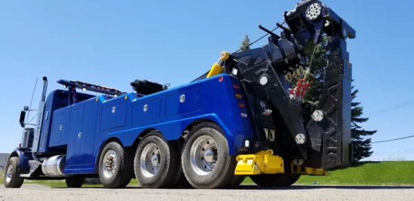 INT-60 heavy duty integrated wrecker operating with boom and stabilizers deployed for truck recovery service