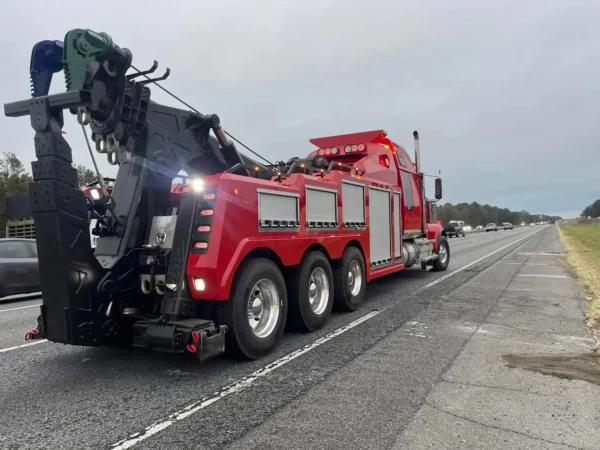 INT-60 integrated heavy wrecker in red towing configuration with boom and underlift on major roadway