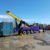 INT-60 integrated wrecker performing container lifting with outriggers out and boom extended and winches