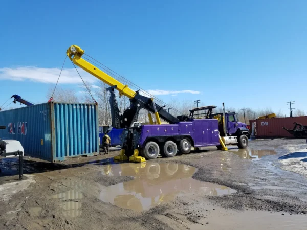 INT-60 integrated wrecker performing container lifting with outriggers out and boom extended and winches