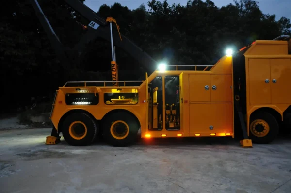 INT-60 heavy duty integrated wrecker performing nighttime towing and recovery operations with boom deployed