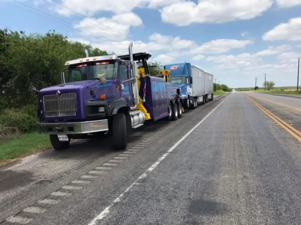 INT-60 heavy duty integrated wrecker towing a tractor-trailer combination on the highway