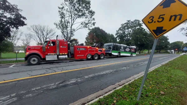 A red INT-60 heavy tow truck staged roadside for towing a bus