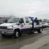 White and blue INT-5 tow truck roadside view showing underlift forks