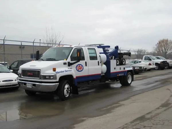 White and blue INT-5 tow truck roadside view showing underlift forks