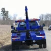 Metro Tow Trucks INT-5 blue integrated wrecker rear view with boom lifted on rural roadside