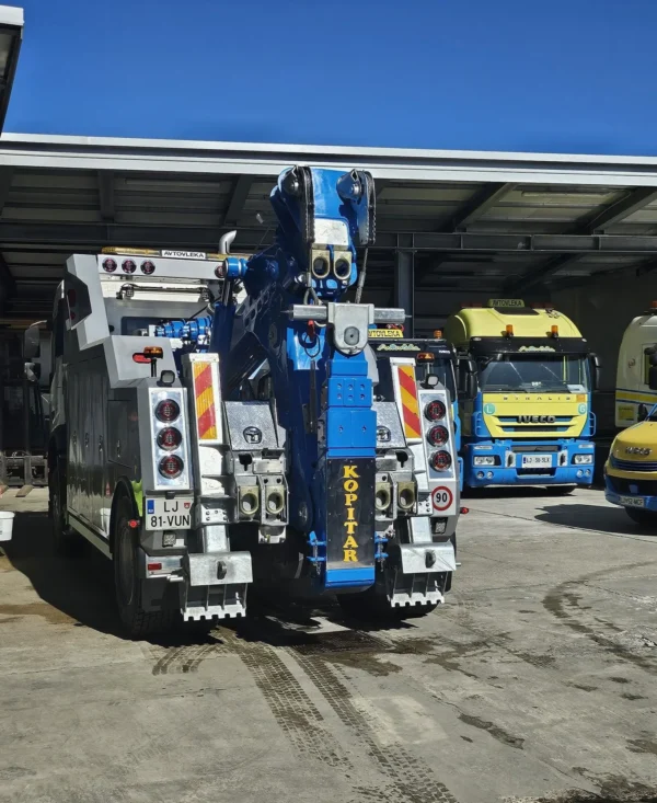 Metro Tow Trucks INT-30 heavy-duty integrated wrecker rear view with blue underlift system in service yard