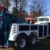 Finished Integrated INT-30 heavy duty wrecker with body painted white and boom painted blue, parked outdoors