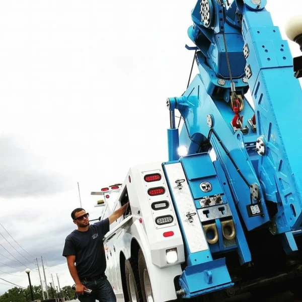 Operator inspecting the boom and control panel of an Integrated INT-30 wrecker