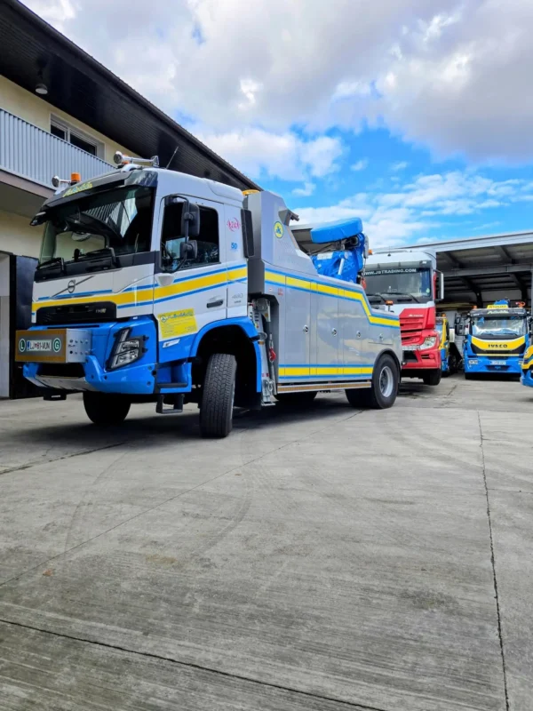 Metro Tow Trucks INT-30 heavy-duty integrated wrecker left side profile with blue boom parked outdoors