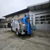 Metro Tow Trucks INT-30 heavy-duty integrated wrecker rear angled view with blue wheel-lift in industrial area