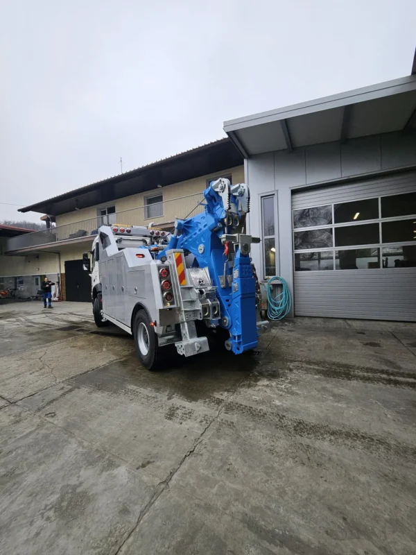 Metro Tow Trucks INT-30 heavy-duty integrated wrecker rear angled view with blue wheel-lift in industrial area