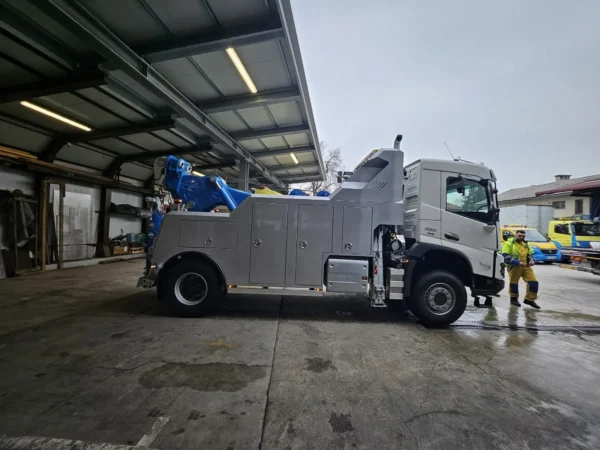 Integrated INT-30 integrated wrecker parked outdoors with boom raised during equipment inspection