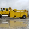 Metro Tow Trucks RTR-16 rotator parked near water puddles on cloudy worksite