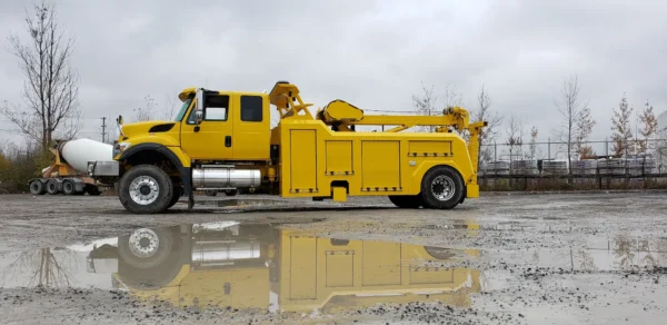 Metro Tow Trucks RTR-16 rotator parked near water puddles on cloudy worksite