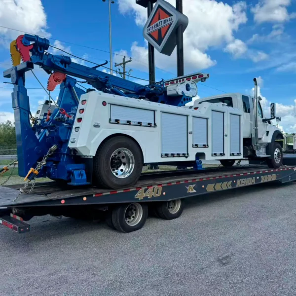 White and blue Metro RTR-16 rotator on flatbed, heavy truck recovery equipment