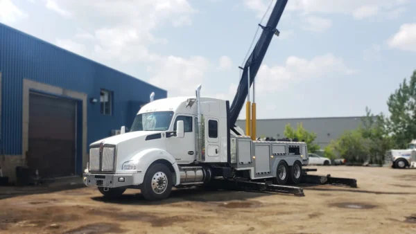 Metro Tow Trucks RTR-35 rotator operating boom near workshop entrance for vehicle lifting