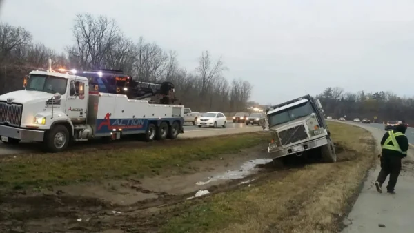 Metro Tow Trucks RTR-35 rotator winching overturned vehicle from muddy roadside