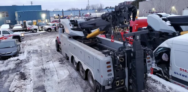 Metro Tow Trucks RTR-50 performing winter recovery operation with boom extended and crew working on scene