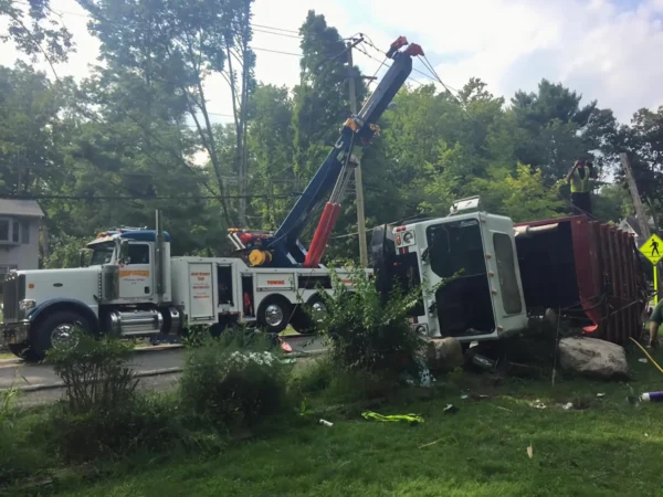 Metro RTR-70 rotator recovering an overturned truck from roadside ditch in emergency scene