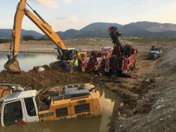 Metro RTR-70 heavy rotator assisting excavator in deep-ditch construction vehicle recovery
