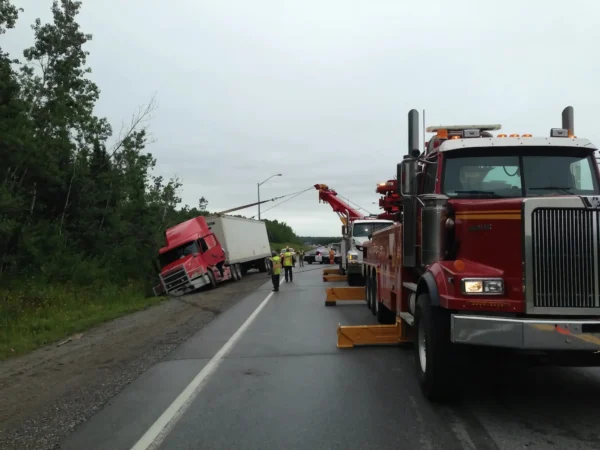 Metro RTR-70 rotator stabilizing and recovering a jackknifed semi-truck on highway shoulder