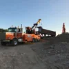 Metro RTR-70 rotator lifting a dump body at sand and gravel pit