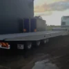 Side view of TSA-50 tri-axle flatbed trailer showing low-profile deck and heavy-duty frame