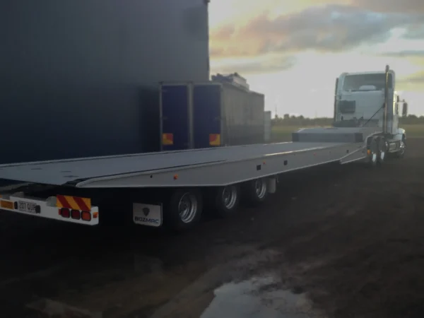 Side view of TSA-50 tri-axle flatbed trailer showing low-profile deck and heavy-duty frame
