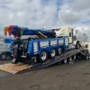 TSA-50 tri-axle trailer loading a heavy duty tow truck wrecker using low-angle deck ramps at the job site