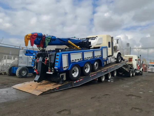 TSA-50 tri-axle trailer loading a heavy duty tow truck wrecker using low-angle deck ramps at the job site