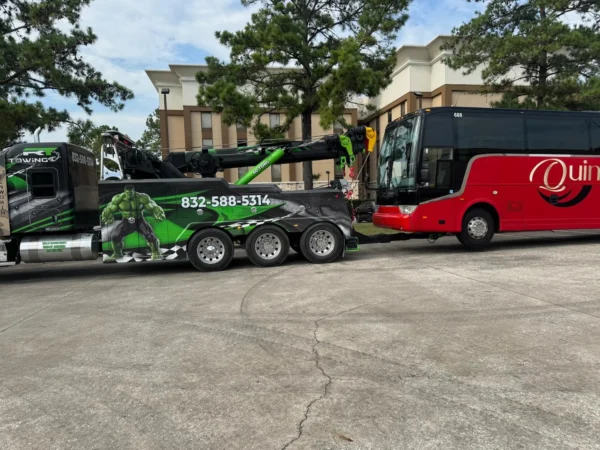 IND-60 independent wrecker towing a passenger coach with underlift, displaying outriggers and boom setup