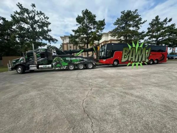 Metro Tow Trucks IND-60 heavy wrecker towing a coach bus on highway lot