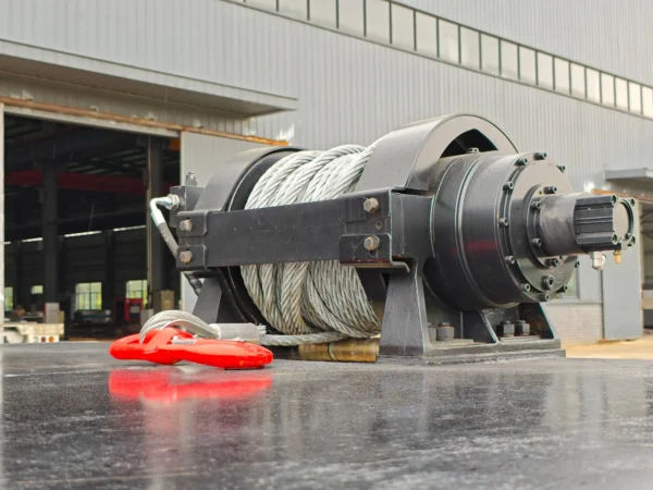 STT-50 deck-mounted heavy-duty winch with steel cable and safety hook, positioned at the front of the trailer