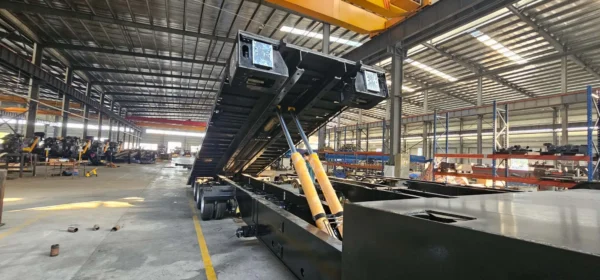 STT-50 trailer on hydraulic tilt inside factory, demonstrating loading angle and under-deck structure