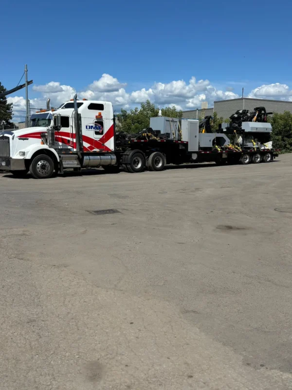 STT-50 trailer hooked to a highway tractor, transporting industrial equipment across a yard