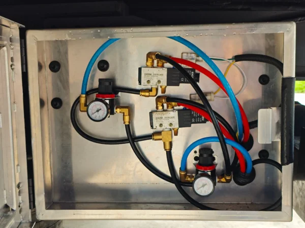 STT-50 trailer hydraulic control box showing valves, hoses, and pressure lines inside the sealed compartment