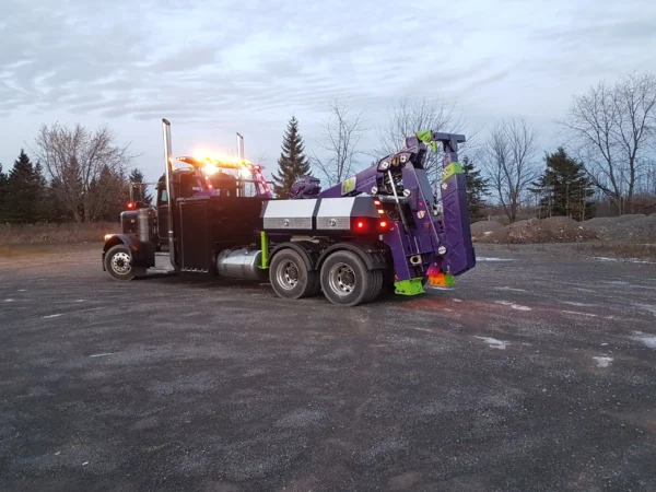 Metro MDTU-20 detachable towing unit mounted on heavy-duty truck, left rear side view, parked outdoors at dusk