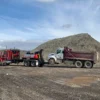 MDTU-20 detachable tow unit towing a dump truck at a gravel yard with underlift engaged