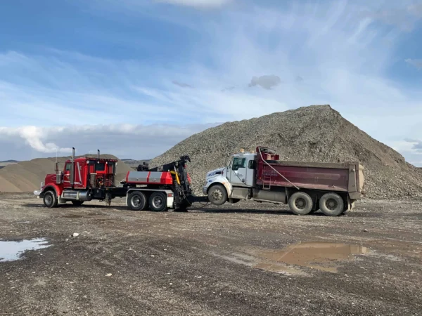 MDTU-20 detachable tow unit towing a dump truck at a gravel yard with underlift engaged