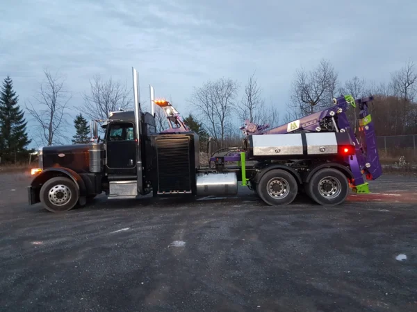 “MDTU-20 detachable tow unit on heavy-duty tri-axle truck, side view parked on asphalt in outdoor yard