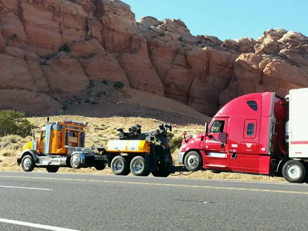MDTU-35 detachable towing unit transporting a semi-truck on a highway near red rock scenery