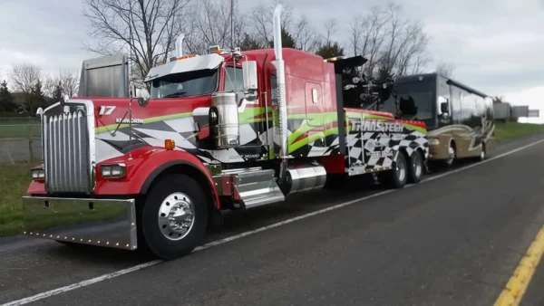 Custom-painted Metro RTR-25 rotator wrecker towing a bus on highway