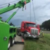 Metro Tow Trucks RTR-25 rotator recovery truck winching a damaged red truck from shoulder